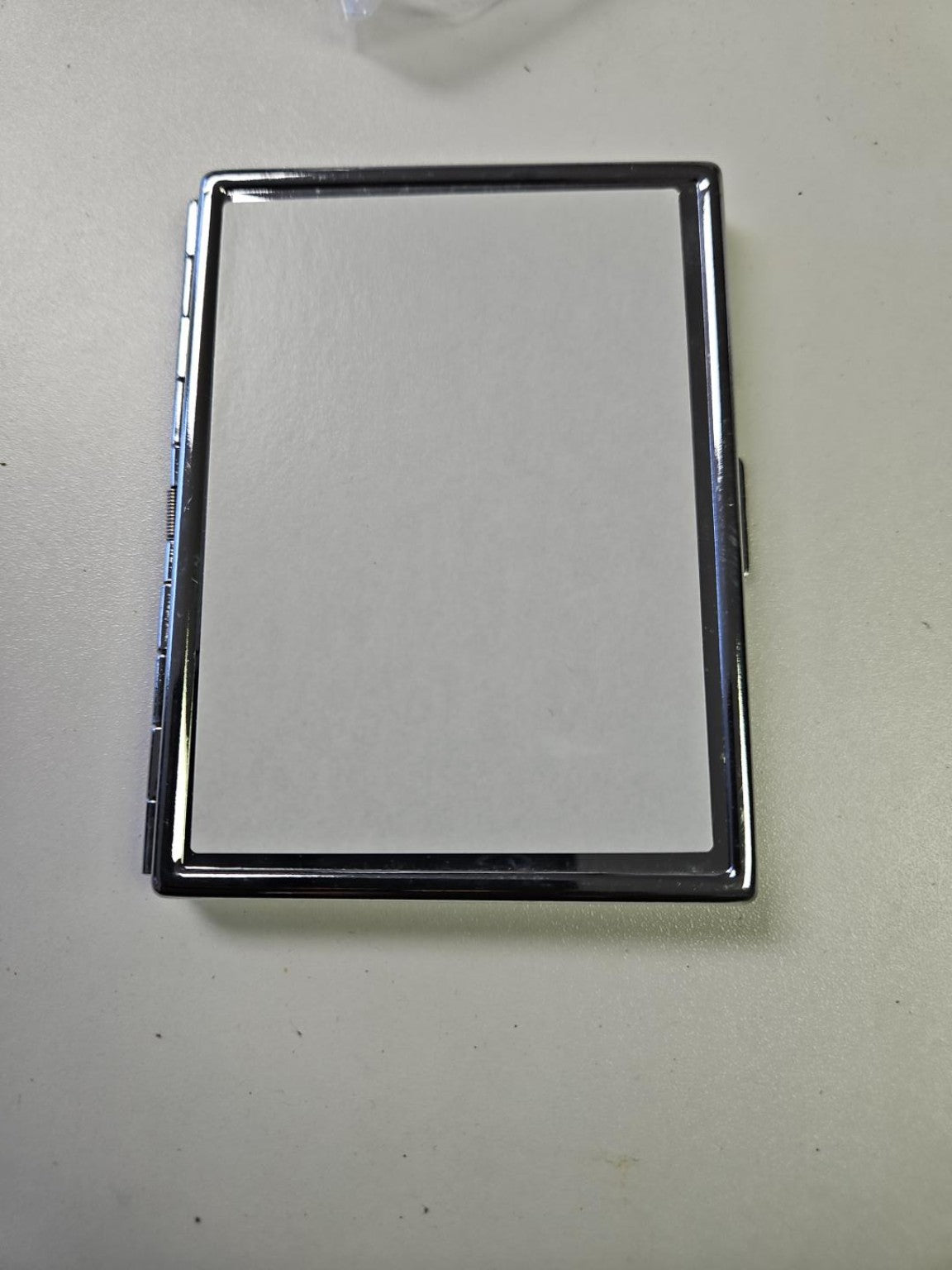 Closed silver metal business card holder with rectangular white sublimation-ready front panel