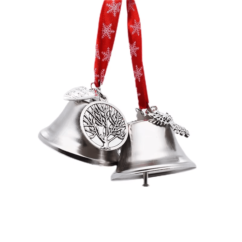 Silver Christmas bells hanging from a red snowflake ribbon with decorative tree charms