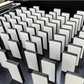 Rows of blank white sublimation domino tiles standing upright