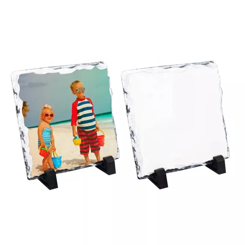Two square sublimation photo rock slates on display stands, one printed with a beach photo and one blank white