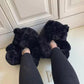 Black teddy bear slippers worn on feet