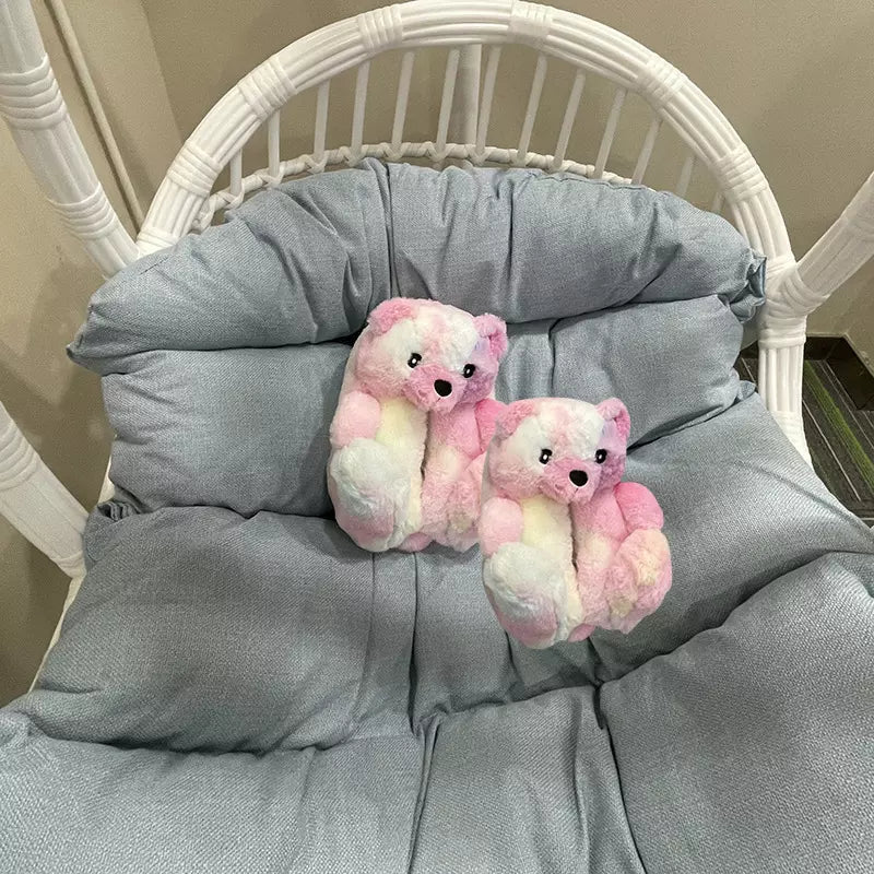 Pink and white teddy bear slippers on a chair